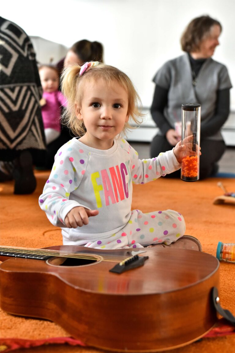 Child experiencing the musical instruments during a music class.