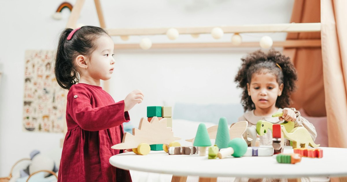 Two young children playing with toys indoors
